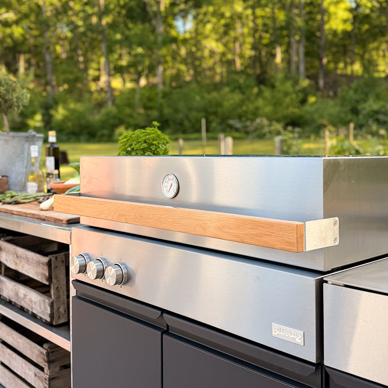 Bluegaz Z Gasolgrill med Z Sidomodul sett från sidan med grönska i bakgrunden