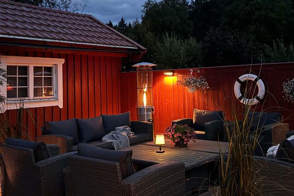 Bluegaz Teide Terrassvärmare brinner på uteplats under kvällstid framför soffgrupp
